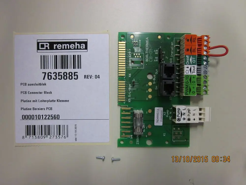 Remeha Elektroplatine mit mehreren Anschlussklemmen und zwei Netzwerkports. Neben der Platine sind Schrauben abgebildet. Sichtbare Produktinformationen sind auf dem Etikett aufgedruckt.